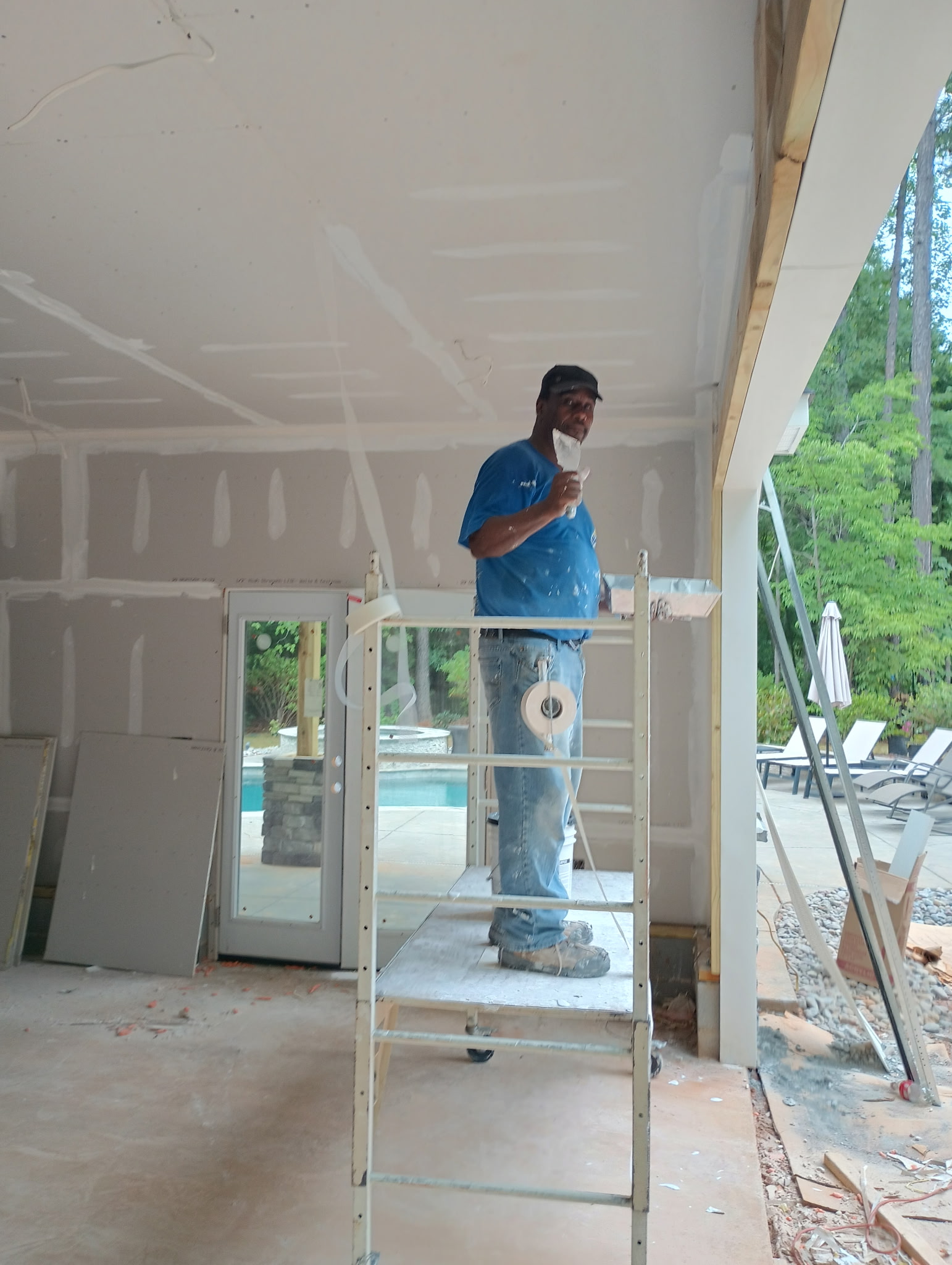 Drywall contractor working on scaffold